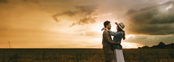 istock beautiful couple embracing on meadow at sunset 1017900868