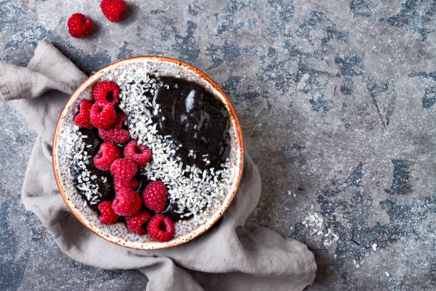 istock Activated charcoal smoothie and chia seed pudding bowl, vegan detox dessert with raspberry and coconut milk. Overhead, top view, flat lay 1017903788