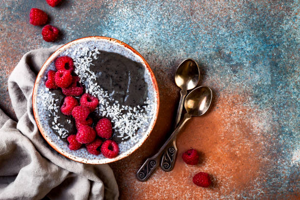 istock Activated charcoal smoothie and chia seed pudding bowl, vegan detox dessert with raspberry and coconut milk. Overhead, top view, flat lay 1017903792