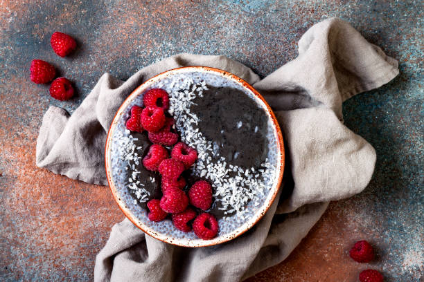 istock Activated charcoal smoothie and chia seed pudding bowl, vegan detox dessert with raspberry and coconut milk. Overhead, top view, flat lay 1017903796