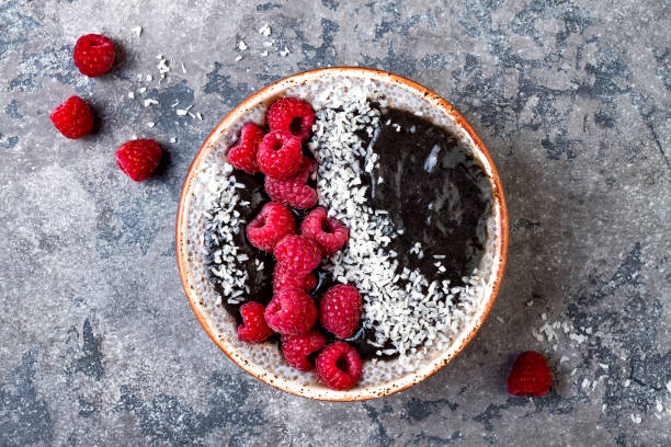 istock Activated charcoal smoothie and chia seed pudding bowl, vegan detox dessert with raspberry and coconut milk. Overhead, top view, flat lay 1017905062