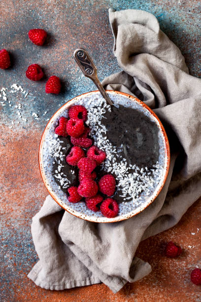 istock Activated charcoal smoothie and chia seed pudding bowl, vegan detox dessert with raspberry and coconut milk. Overhead, top view, flat lay 1017905758
