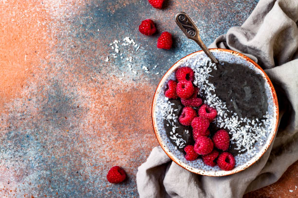 istock Activated charcoal smoothie and chia seed pudding bowl, vegan detox dessert with raspberry and coconut milk. Overhead, top view, flat lay 1017905830