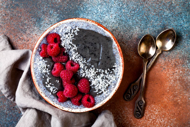 istock Activated charcoal smoothie and chia seed pudding bowl, vegan detox dessert with raspberry and coconut milk. Overhead, top view, flat lay 1017905834