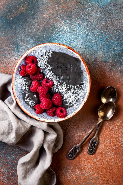 istock Activated charcoal smoothie and chia seed pudding bowl, vegan detox dessert with raspberry and coconut milk. Overhead, top view, flat lay 1017905838