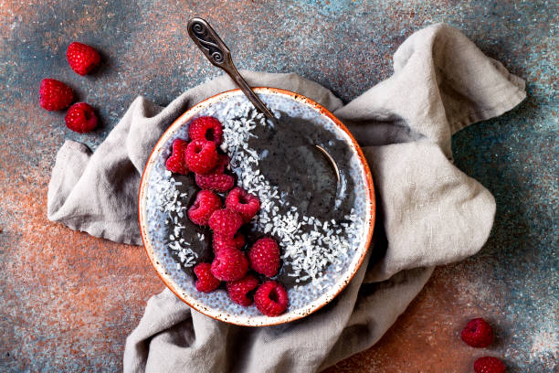 istock Activated charcoal smoothie and chia seed pudding bowl, vegan detox dessert with raspberry and coconut milk. Overhead, top view, flat lay 1017905848