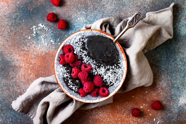 istock Activated charcoal smoothie and chia seed pudding bowl, vegan detox dessert with raspberry and coconut milk. Overhead, top view, flat lay 1017905870