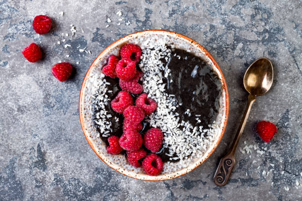 istock Activated charcoal smoothie and chia seed pudding bowl, vegan detox dessert with raspberry and coconut milk. Overhead, top view, flat lay 1017905872
