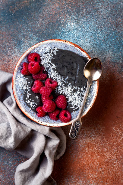 istock Activated charcoal smoothie and chia seed pudding bowl, vegan detox dessert with raspberry and coconut milk. Overhead, top view, flat lay 1017905902