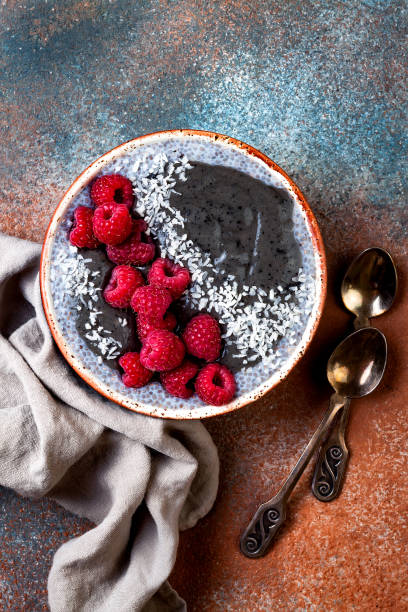 istock Activated charcoal smoothie and chia seed pudding bowl, vegan detox dessert with raspberry and coconut milk. Overhead, top view, flat lay 1017905924