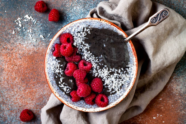 istock Activated charcoal smoothie and chia seed pudding bowl, vegan detox dessert with raspberry and coconut milk. Overhead, top view, flat lay 1017906092
