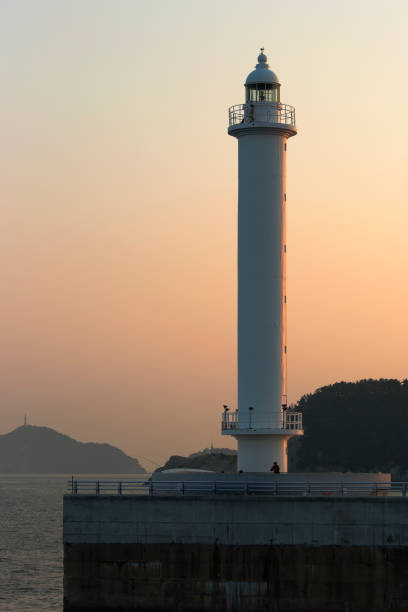 istock lighthouse at the exit of the port illuminated by the sunset 1017932414