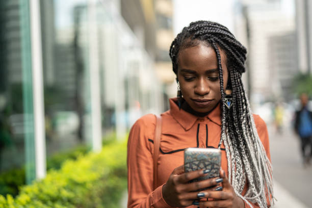 istock Afro Woman Using Mobile at Street 1017932504