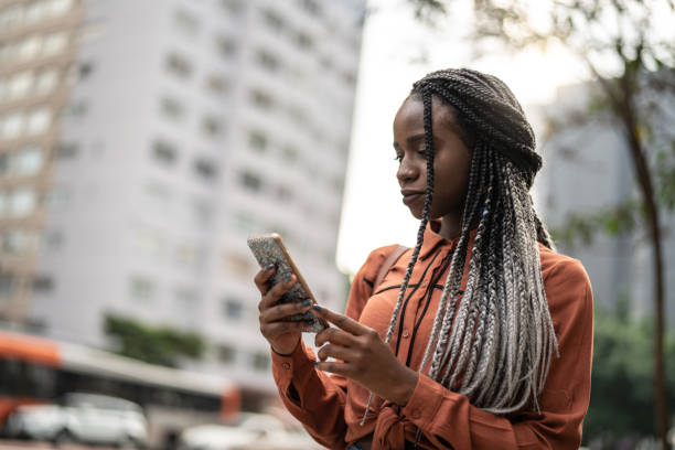 istock Afro Woman Using Mobile at Street 1017932558