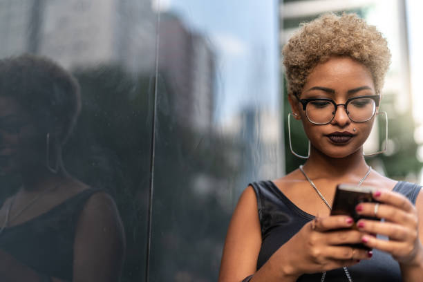 Young Woman Using Mobile Always Connected black man blonde hair stock pictures, royalty-free photos & images