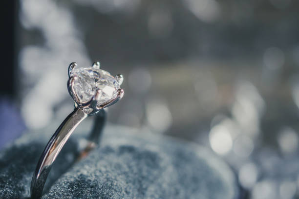 istock luxury engagement Diamond ring in jewelry gift box with bokeh light background 1017943496