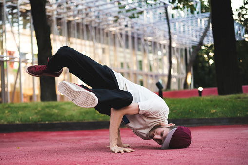 young hip hop street dancer in the city during the dusk doing freeze