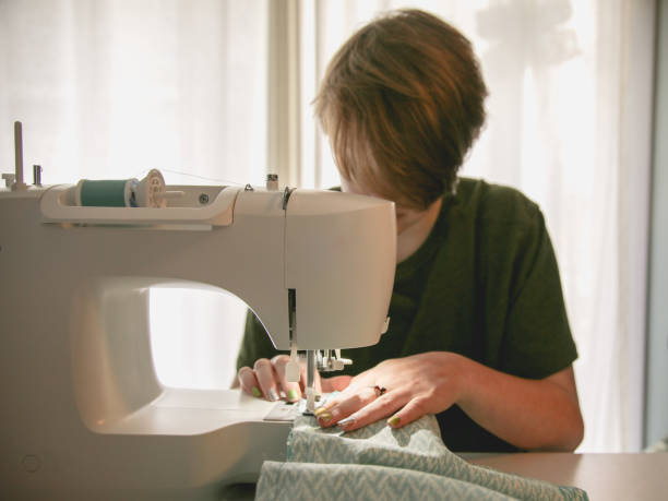 istock DIY Sewing Project White and Green, Hand Pushing Fabric 1017973474