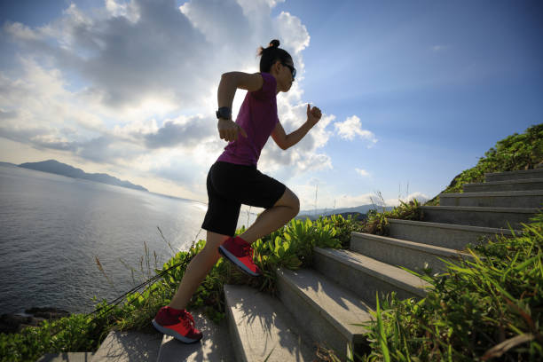 istock Woman runner running up on seaside mountain stairs 1017979290
