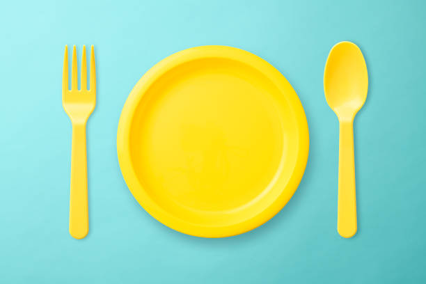 istock Yellow plastic plate, Folk, and spoon on blue background 1017981478