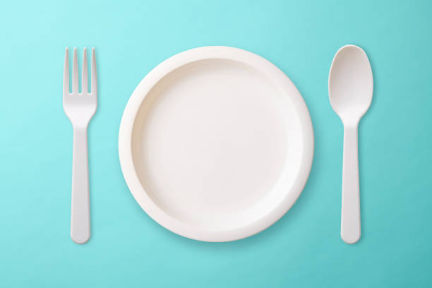 istock White plastic plate, Folk, and spoon on blue background 1017981480