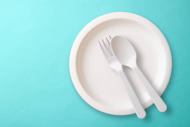 istock White plastic plate with Folk, and spoon on blue background 1017981494
