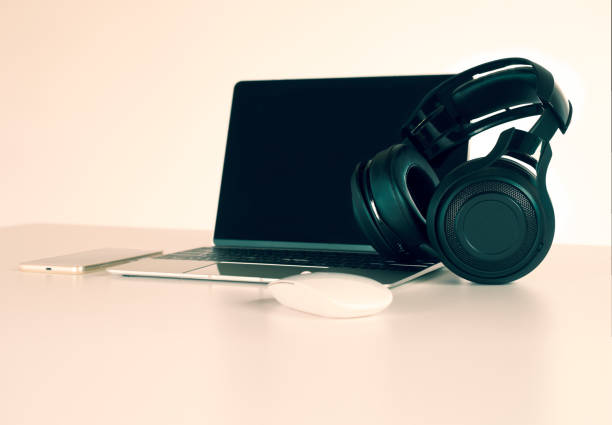 istock Headphones black, smartphone and laptop on Work Desk. 1017989106