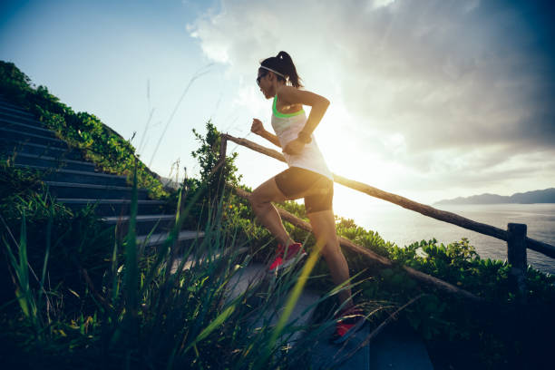 Determined woman running up on seaside mountain stairs