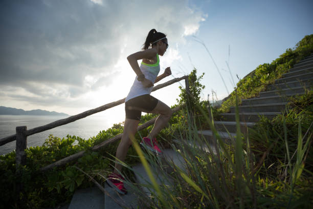 istock Determined woman running up on seaside mountain stairs 1017992092