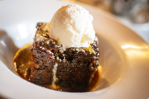 Sticky toffee pudding served with ice-cream Sticky toffee pudding is a British dessert consisting of a very moist sponge cake, made with finely chopped dates, covered in a toffee sauce and often served with a vanilla custard or vanilla ice-cream sticky stock pictures, royalty-free photos & images