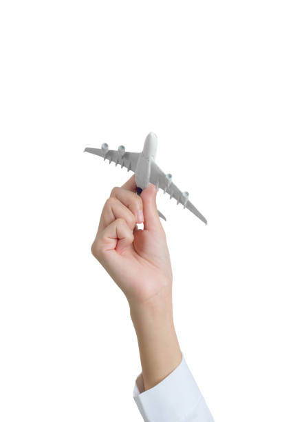 Woman hand holding model aeroplane, isolated on white background.