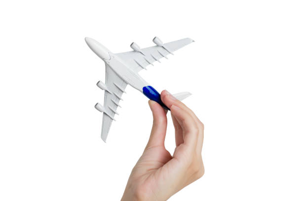 istock Woman hand holding model aeroplane, isolated on white background. 1018011754