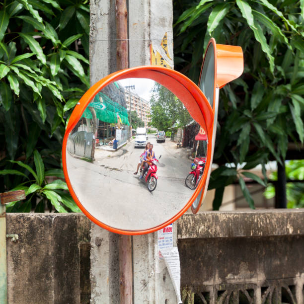 Convex blind spot mirror attached to a  wall on a sharp lane corner