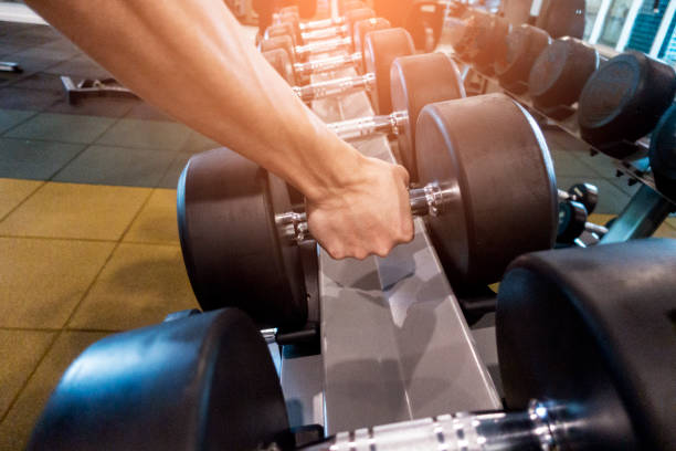 istock Human Hand holding dumbbell in gym 1018032772