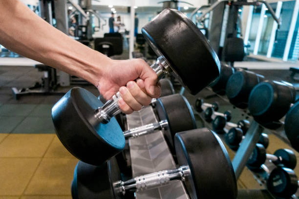 istock Human Hand holding dumbbell in gym 1018032774