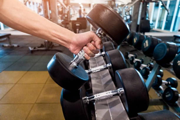 istock Human Hand holding dumbbell in gym 1018032776