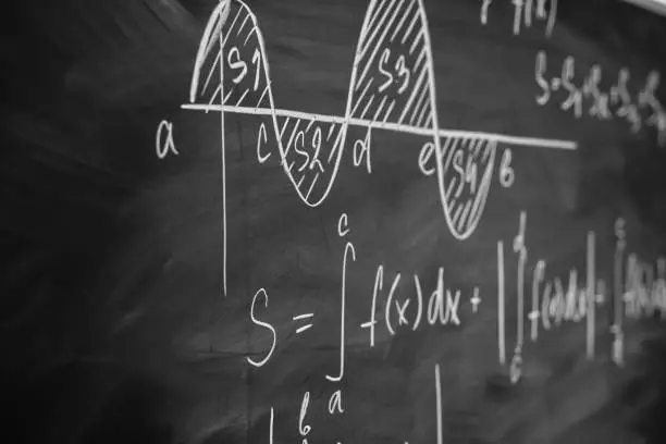 Photo of Mathematics function integra graph formulas on the chalkboard.