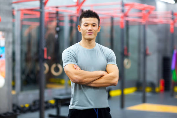 portrait de l’entraîneur personnel chinois dans la salle de gym - coach exercising instructor gym photos et images de collection