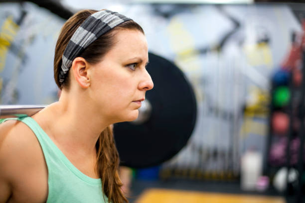 istock Young woman lifting weights in gym 1018043958
