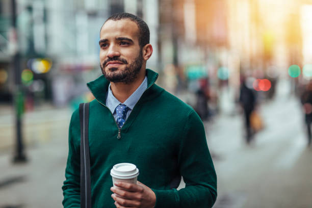 уличный портрет молодого бизнесмена, держащего чашку кофе - spanish and portuguese ethnicity looking at camera waist up outdoors стоковые фото и изображения