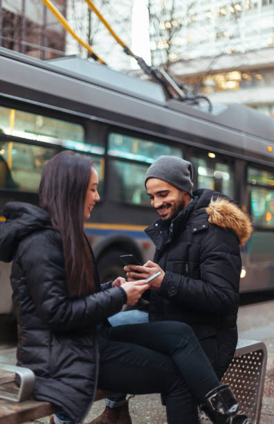 istock Young couple chatting, using smartphone on city street 1018047740
