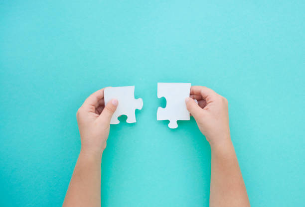 Puzzle pieces on blue background. Autism awareness day.