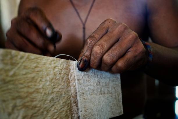 istock ticuna indian tribal member stitching a tree bark artifact together 1018062642