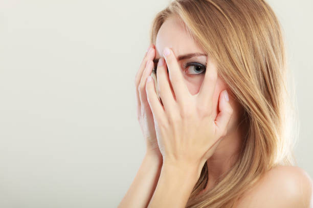 istock Afraid frightened woman peeking through her fingers 1018075966