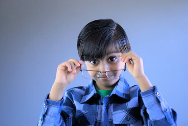 istock Happy kid putting eye glasses on 1018079238
