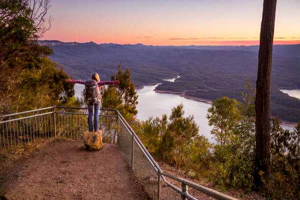 Hiker arriving at a lookout overlooking river valley