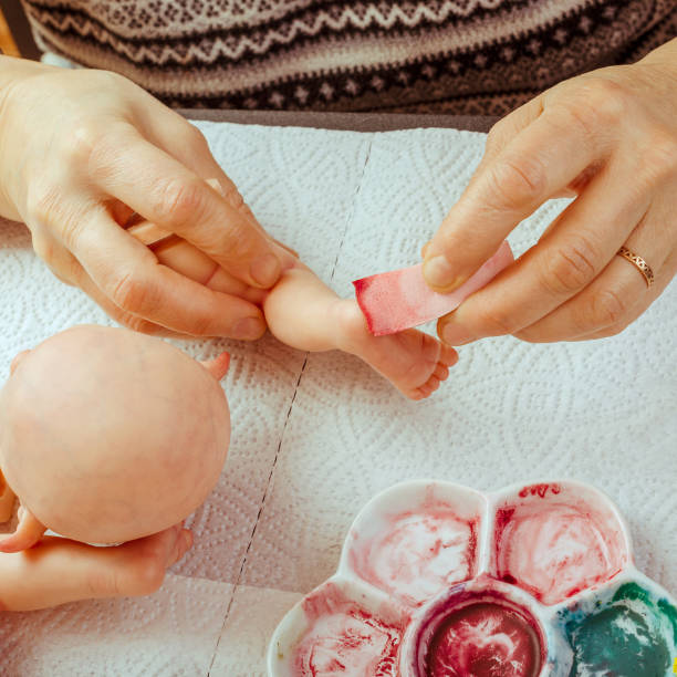 istock Female hands make dolls of BJD or reborn in the workplace. Processing the workpiece. The concept of the craft of the master manufacturer of dolls. Selective focus. For instagram format. 1018092408