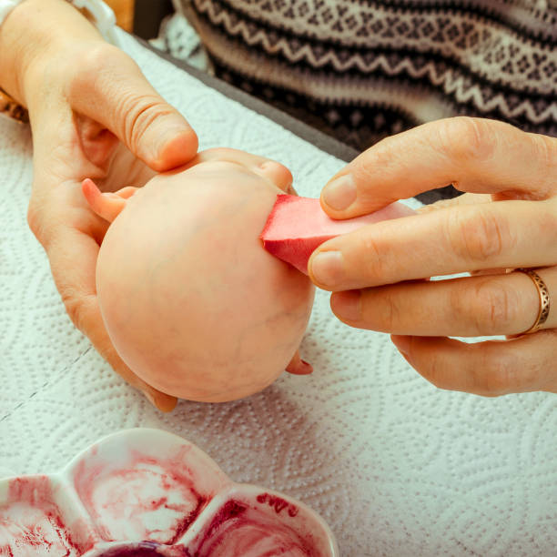 istock Female hands make dolls of BJD or reborn in the workplace. Processing the workpiece. The concept of the craft of the master manufacturer of dolls. Selective focus. For instagram format. 1018092434