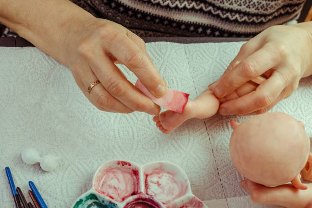 istock Female hands make dolls of BJD or reborn in the workplace. Processing the workpiece. The concept of the craft of the master manufacturer of dolls. Selective focus. 1018092714