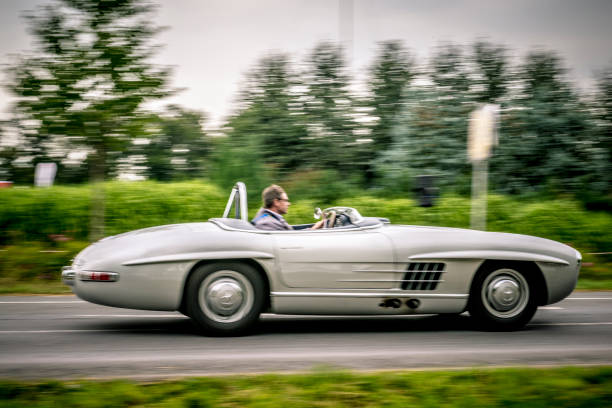 Mercedes-Benz 300 SLS Roadster classic lightweight racing car driving on a country road Mercedes-Benz 300 SLS Roadster classic lightweight racing car driving on a country road. The SLS is a lightweight and more powerful edition of the famous 300 SL Gullwing sports car. The car is doing a demonstration drive during the 2017 Classic Days event at Schloss Dyck. 1950s racing car stock pictures, royalty-free photos & images